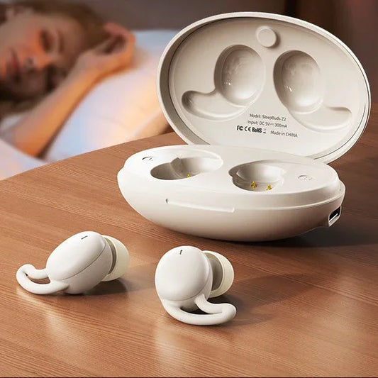 White wireless sleep earbuds with charging case on bedside table, blurred person sleeping in background