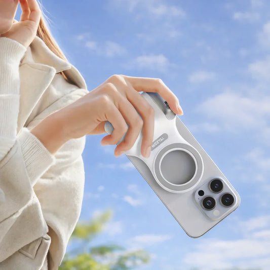 Hand holding smartphone with white MagSafe-compatible case under blue sky