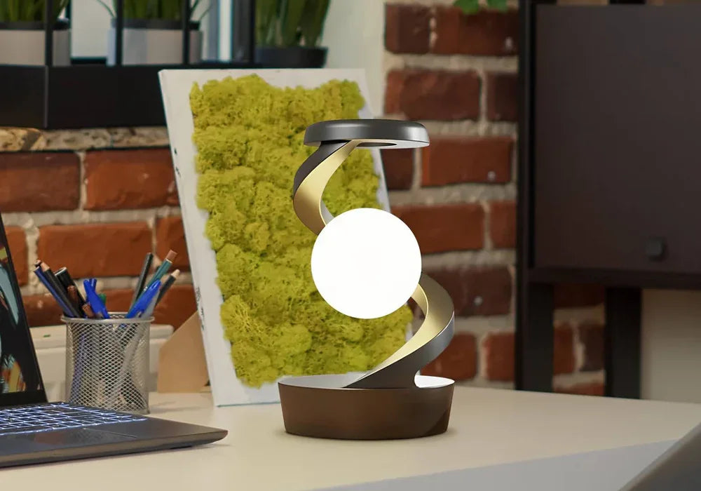 Modern spiral LED desk lamp with glowing orb on an office desk