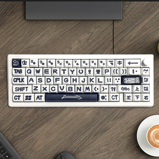 Custom white keyboard with bold icon keycaps on wooden desk, coffee cup nearby.